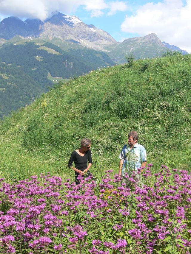 Frau Lazzarini und Rolf Schosser mit Rosenmelisse vor Bergkulisse